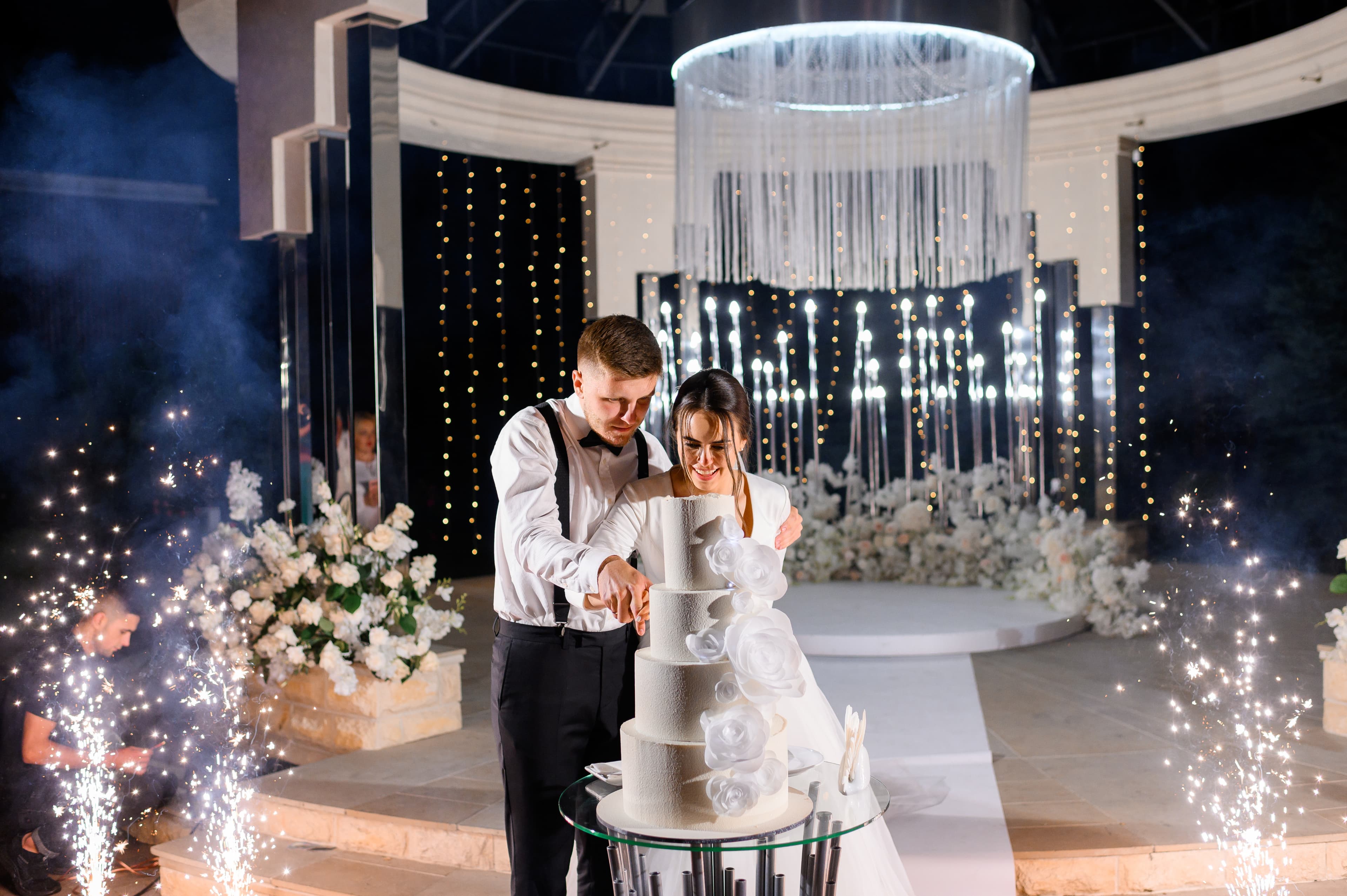 Couple cutting their wedding cake with sparklers